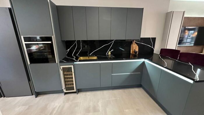 Ex Display Wolds Zola Matt Green Handleless Kitchen with Peninsula – Neff CDA 1810 Appliances – Black with White Marble Effect Quartz Worktops - 3832674
